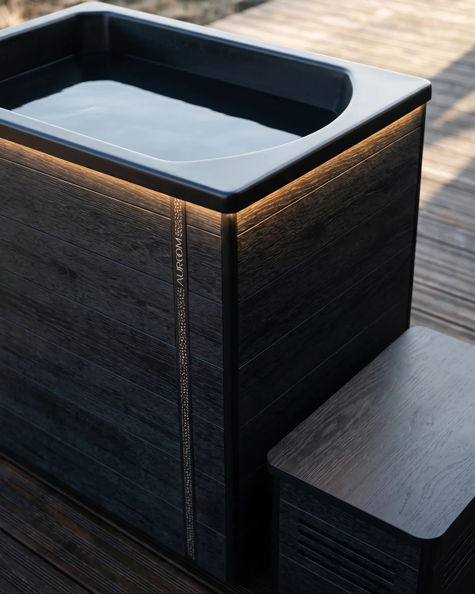 Close-up of a dark Auroom cold plunge filled with still water on a wooden deck